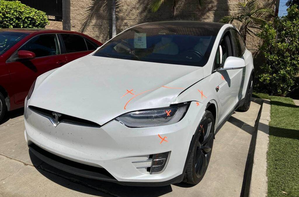 Tesla bumper repair inspection showing front-end collision damage